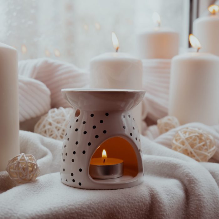 Aroma lamp with essential oil, aromatherapy at home, burning candle, dropping essential oil. Concept of home relaxation and anti stress. Natural Spa treatment Home fragnance at cozy home on the windowsill Hygge aesthetic atmosphere Still life slow living. Mental health wellbeing exercises Raining Outside